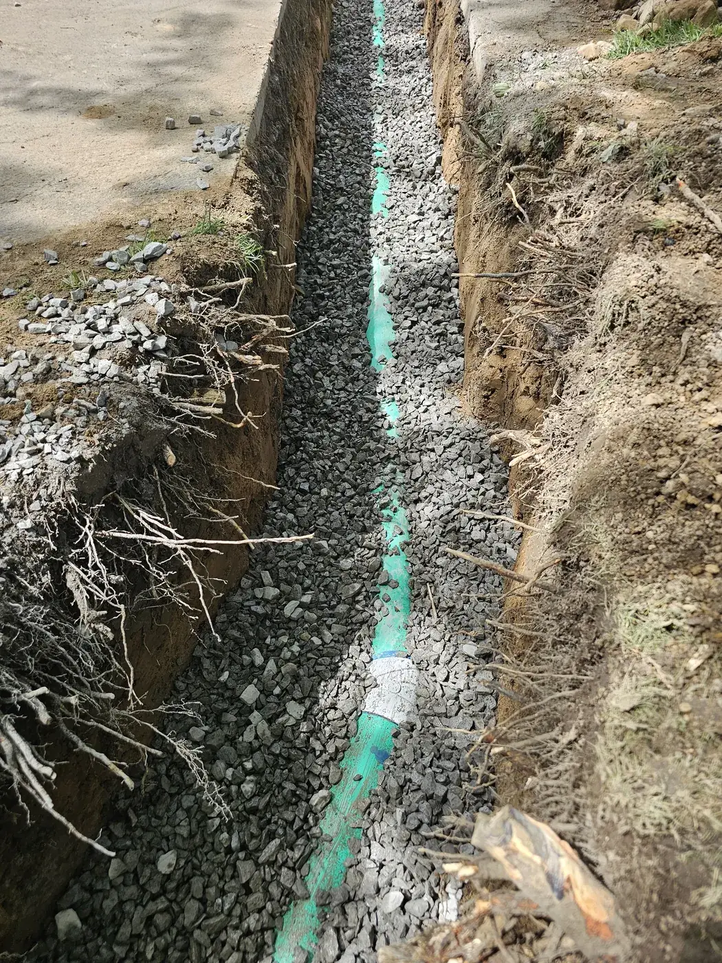Trench lined with gravel and a drain pipe for a French drain