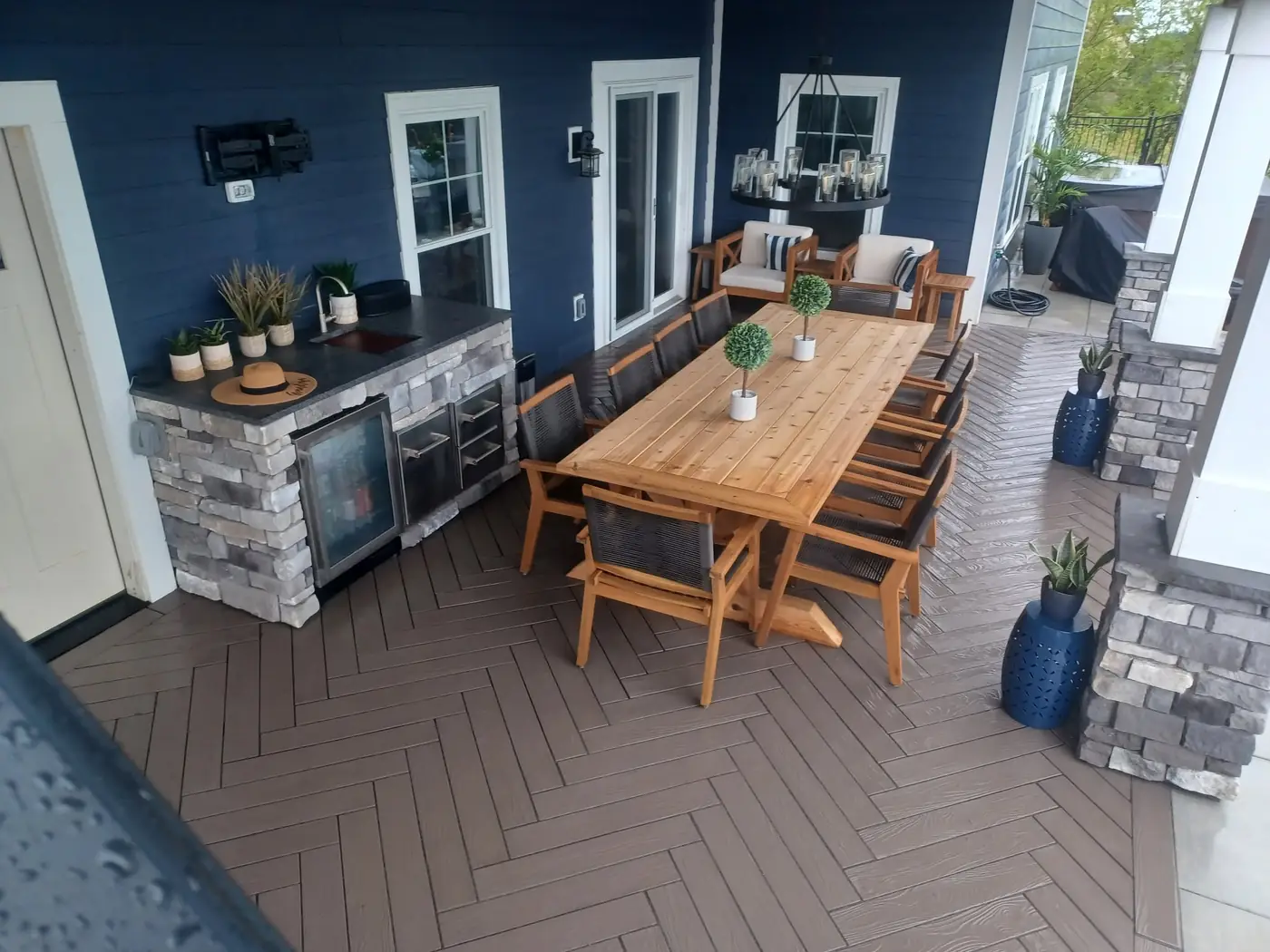 Covered patio with a stone outdoor kitchen counter and dining table