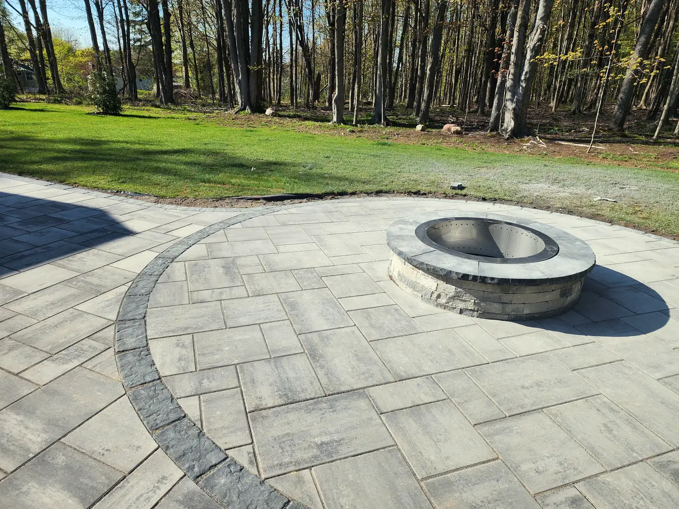 Paver patio with a built in fire pit and a circle accent