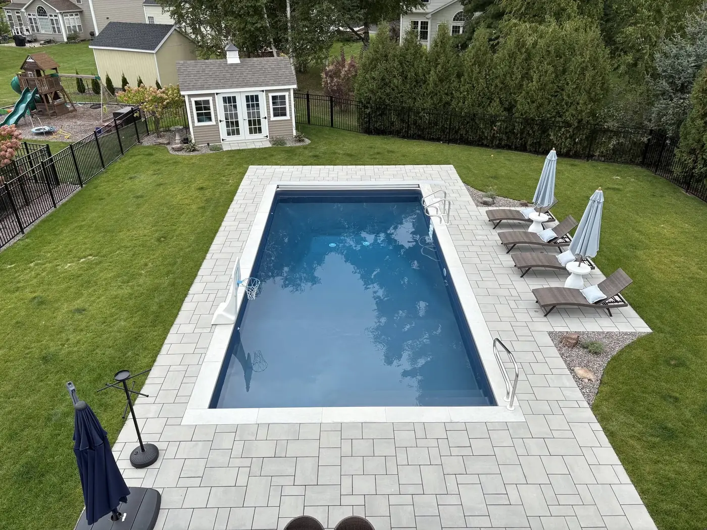 Aerial view of a rectangular pool with a paver surround