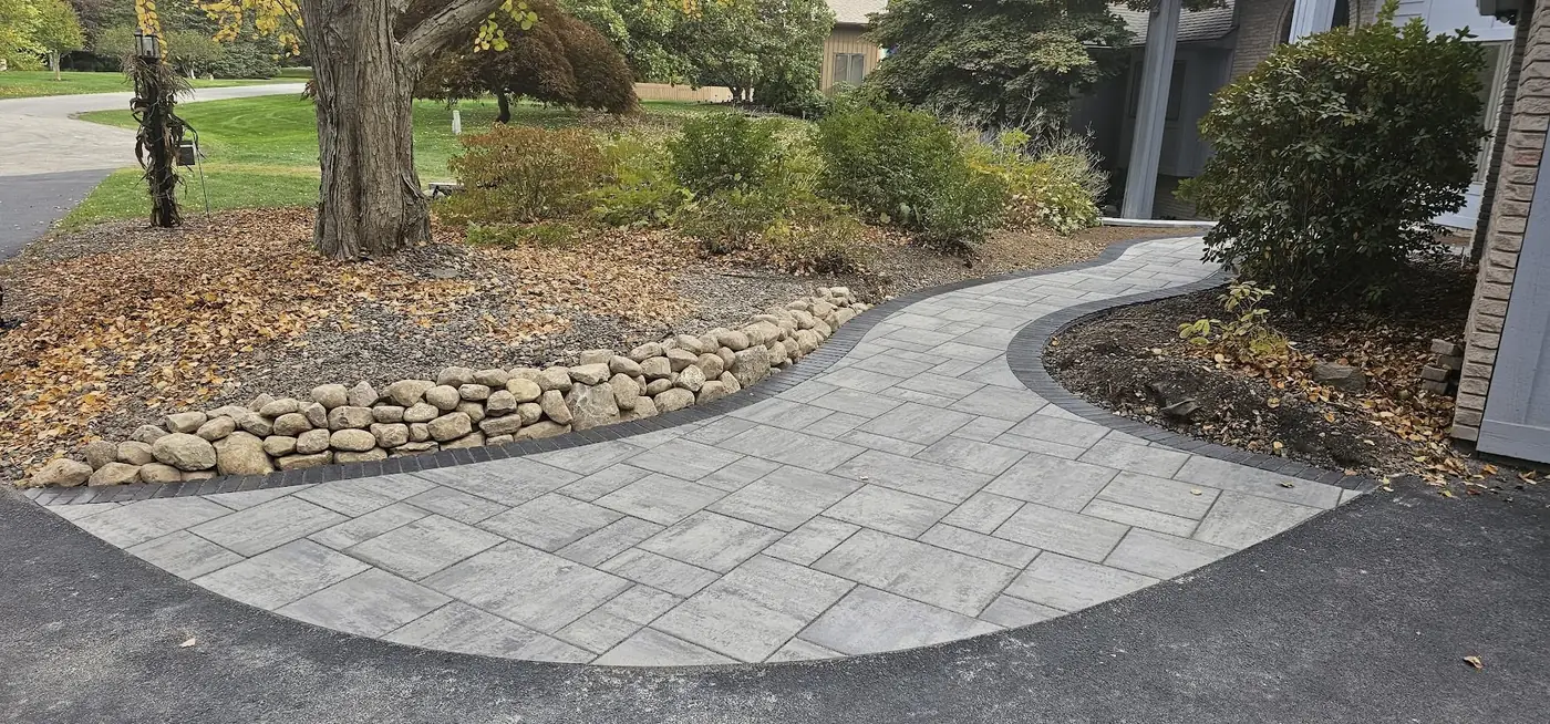 Curved paver walkway lined with landscape beds