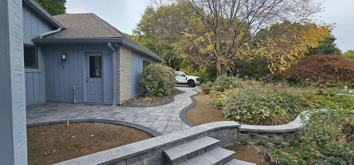 Paver walkway with stone steps and a low retaining wall
